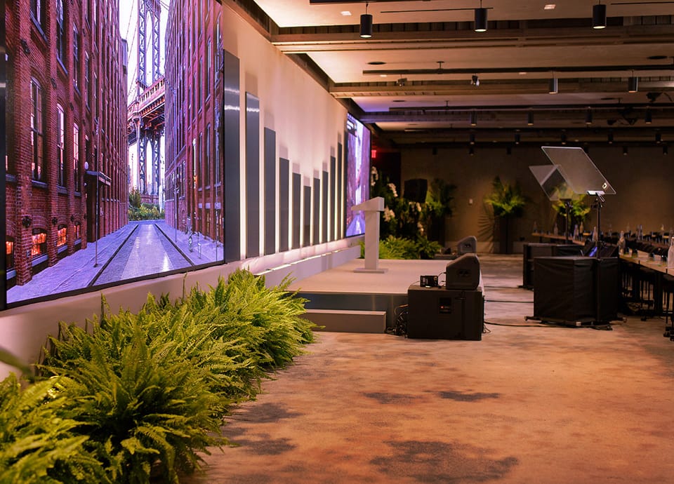 TPG Growth investor event planning stage setup with Brooklyn Bridge on video screen